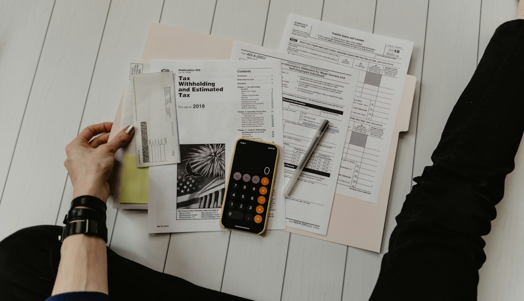Hands sorting through stacks of assessment documents and forms on a white desk