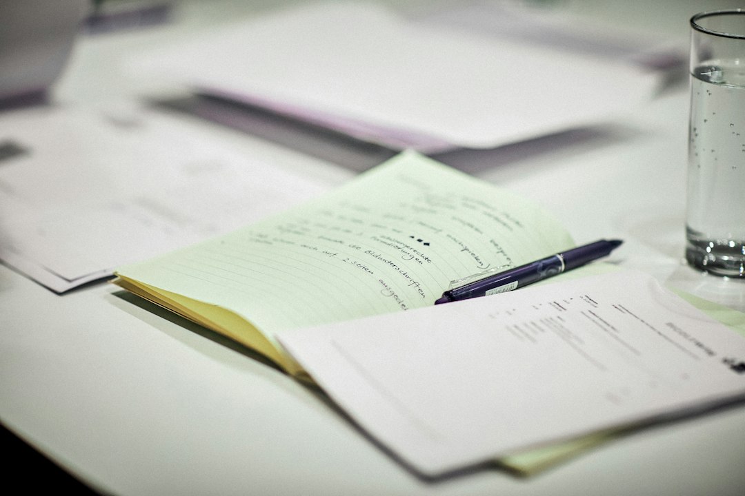Self-study report documents and notes laid out on a desk before review